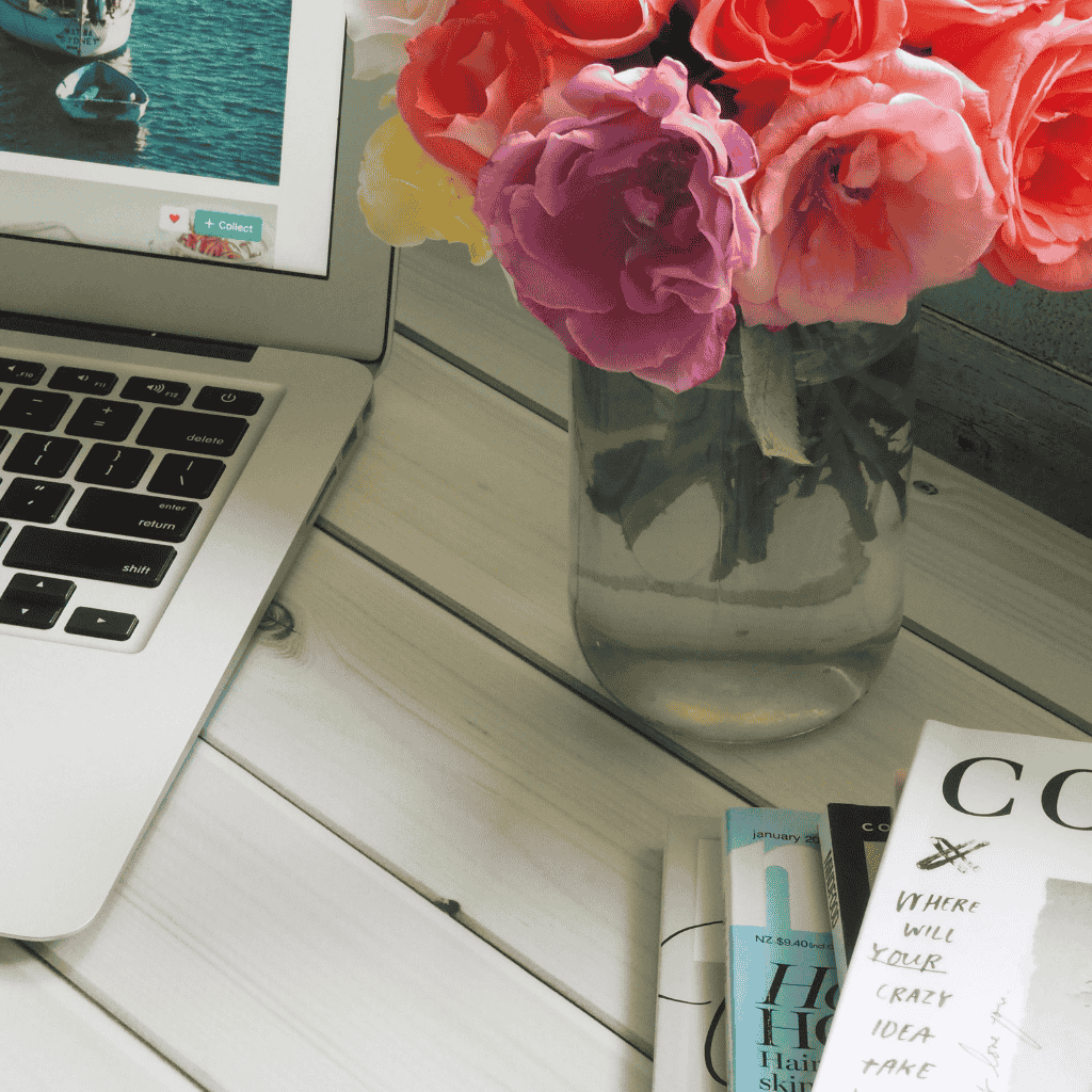 Build a one-page website from scratch using your laptop in a bright creative space with fresh flowers.