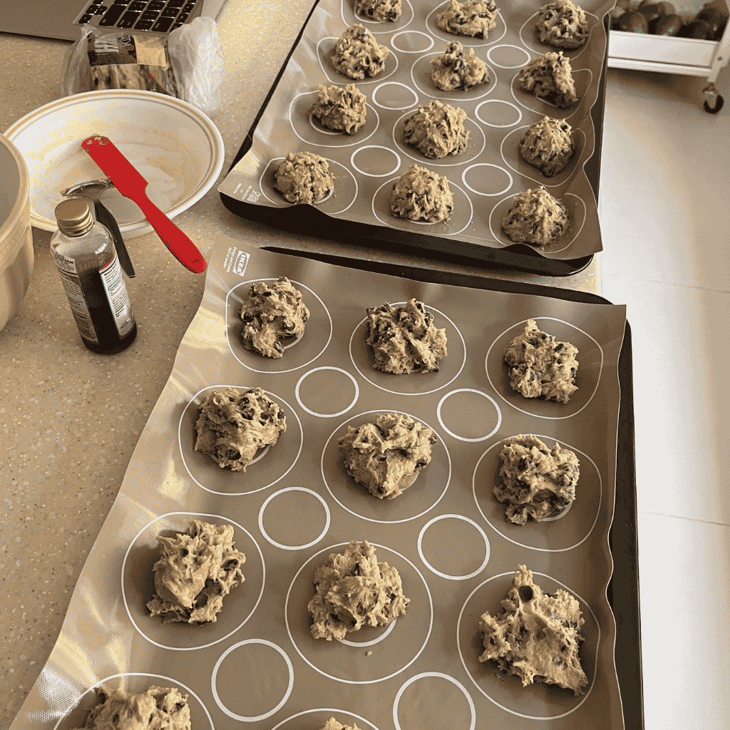 Cookie dough scoops arranged on baking mats ready for the oven.