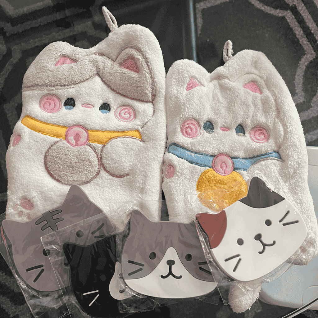 Cute cat-themed mittens and coasters displayed on a table.